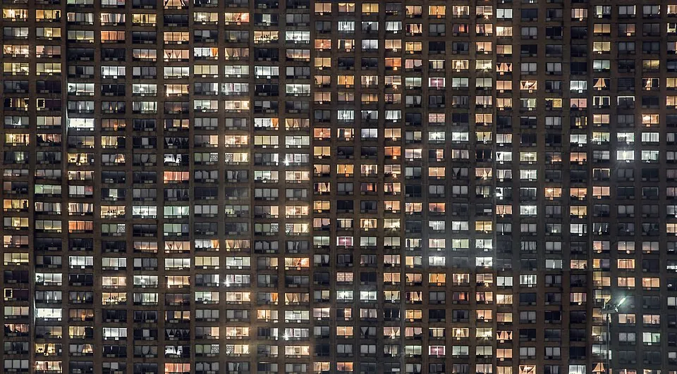 夜、明かりのともる集合住宅の窓