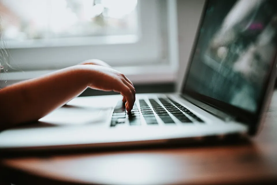 Children's learner typing on the laptop keyboard closeup