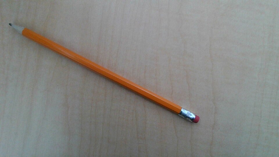 木の机の上に置かれた1本の鉛筆