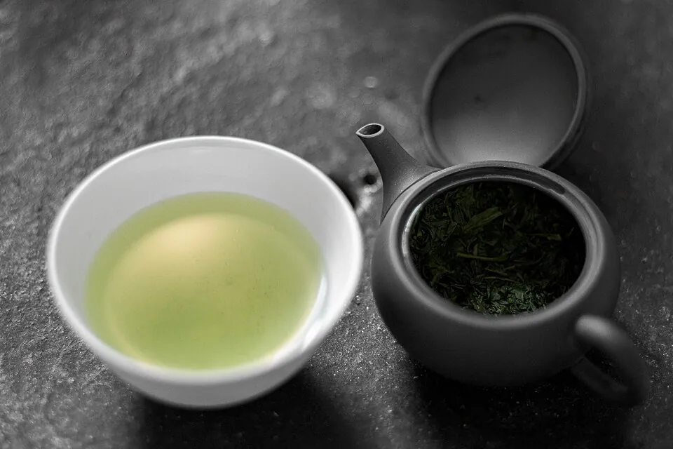 黒い急須と緑茶の入った湯のみ