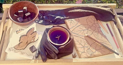 Tea and chocolate in ceramic cups on a small table next to a notebook