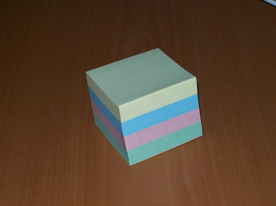 A stack of four colorful sticky notes
