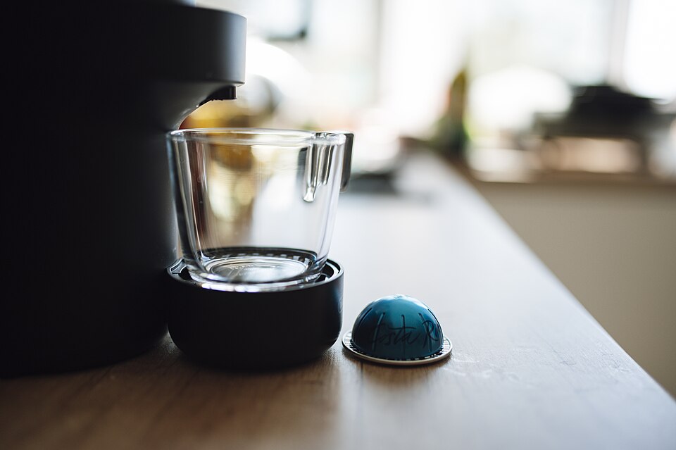 木のテーブルに置かれたコーヒーメーカーとガラスのカップ