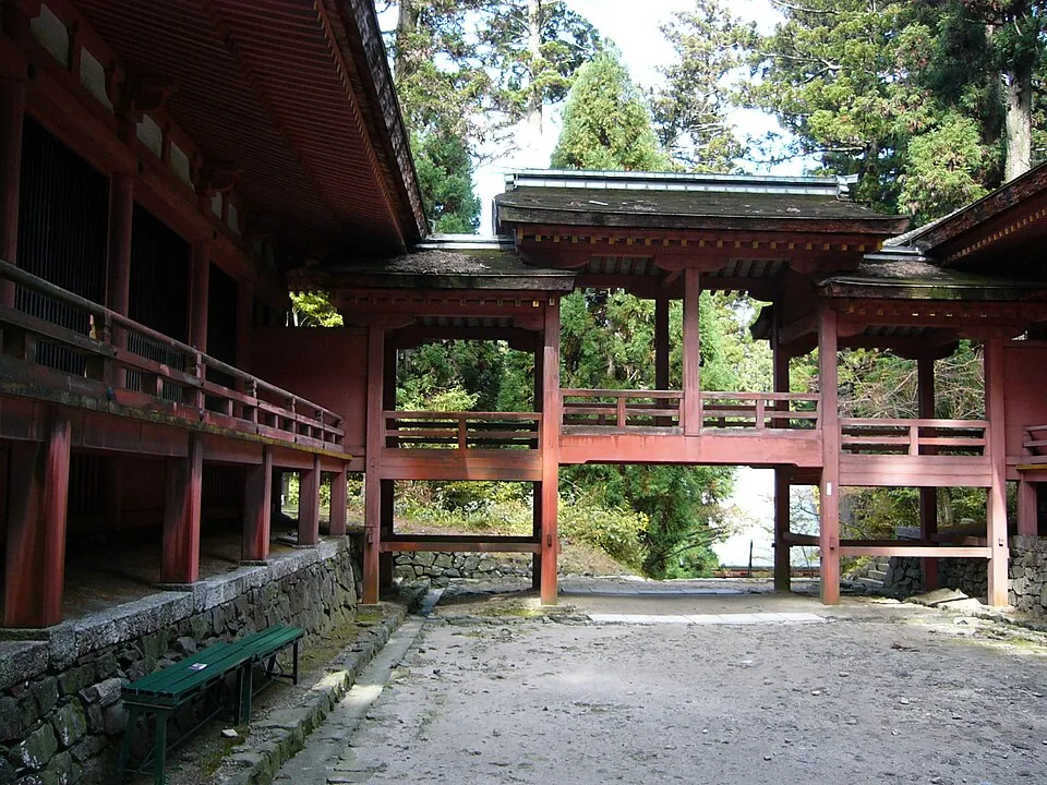 木々に囲まれた寺の渡り廊下とベンチ