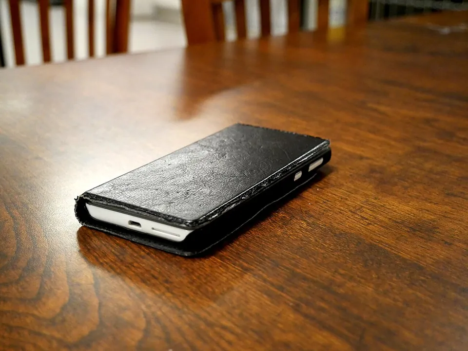 木のテーブルに置かれたスマートフォン